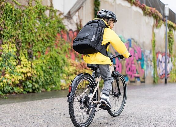 Radfahrender Junge mit Rucksack