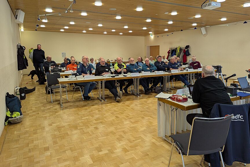 codiertreffen-2025-1 In einem Raum sitzen viele Personen, die angeregt diskutieren