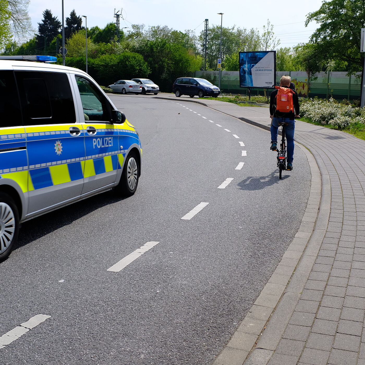 Polizei Auto und Fahrradfahrer auf Schutzsreifen.